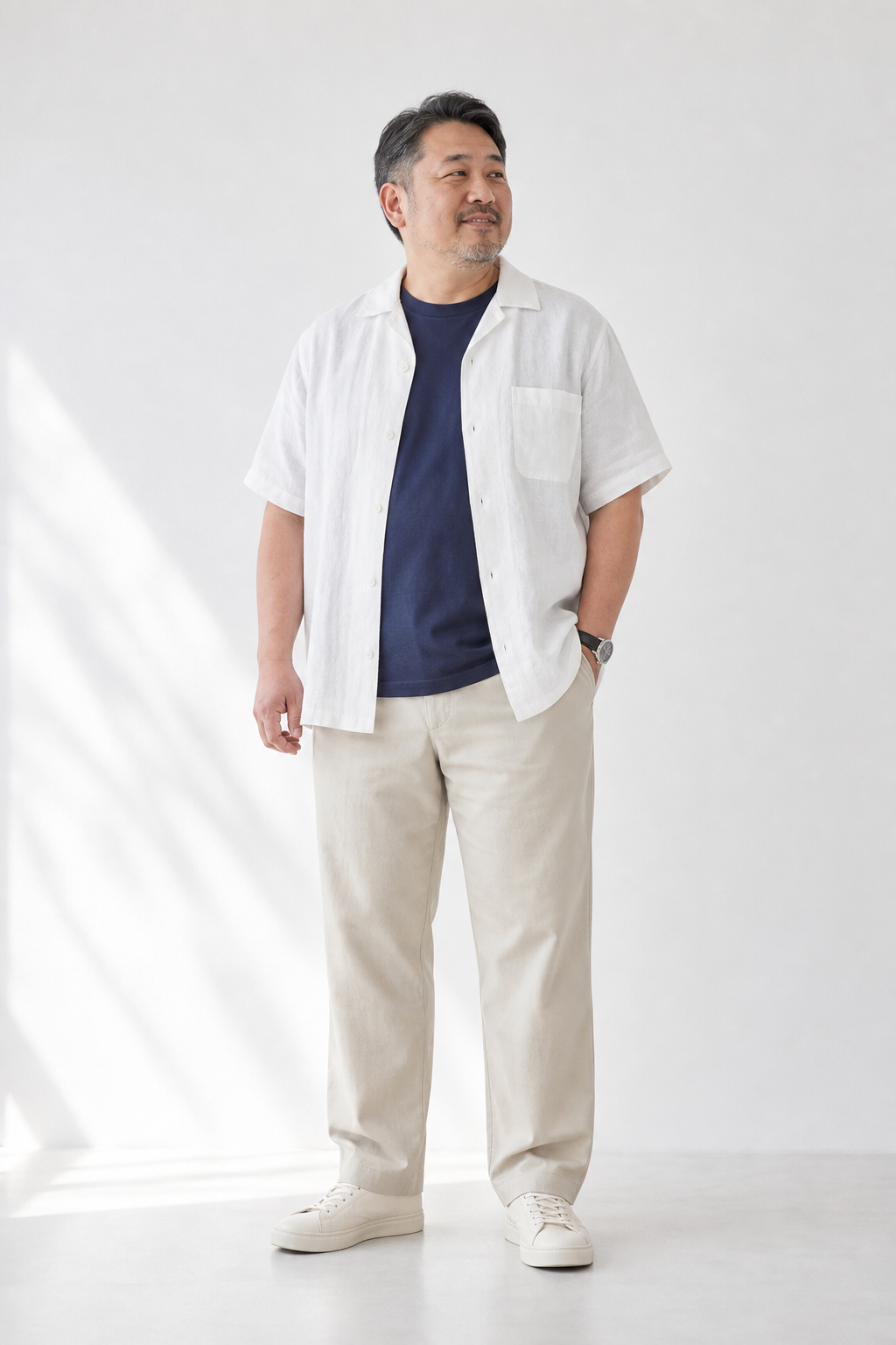 小太りの40代男性に似合う白シャツとネイビーTシャツ、ベージュパンツのきれいめ夏コーデ